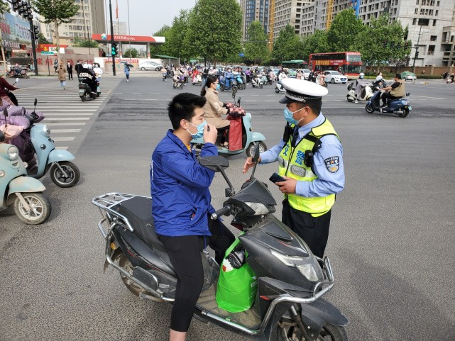 假期后首个早高峰,郑州一路口5分钟内就有10名电动车主因不戴头盔被查